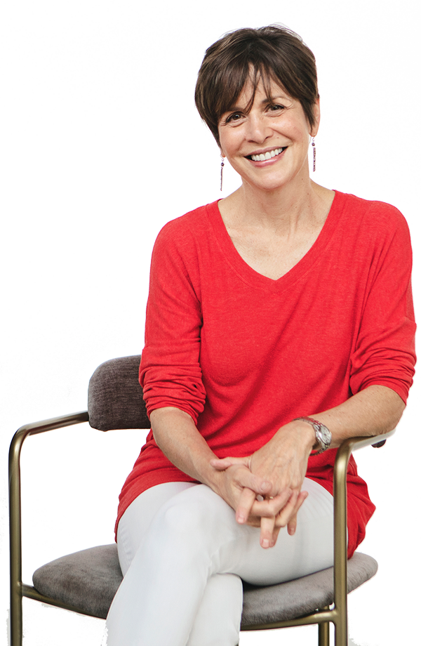 Photo of Linda Goldman sitting in a chair and smiling